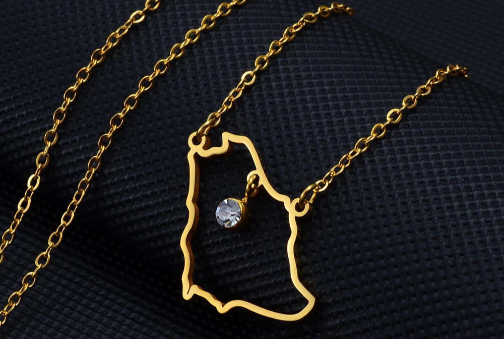 Gold necklace with map pendant and gemstone.