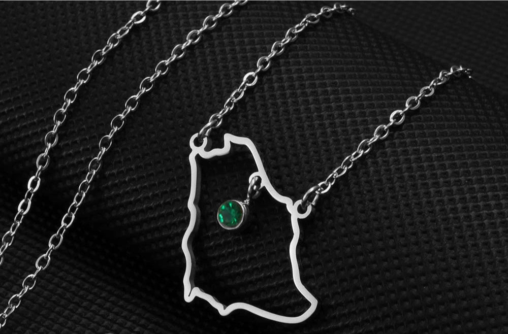 Silver map necklace with green gemstone accent.